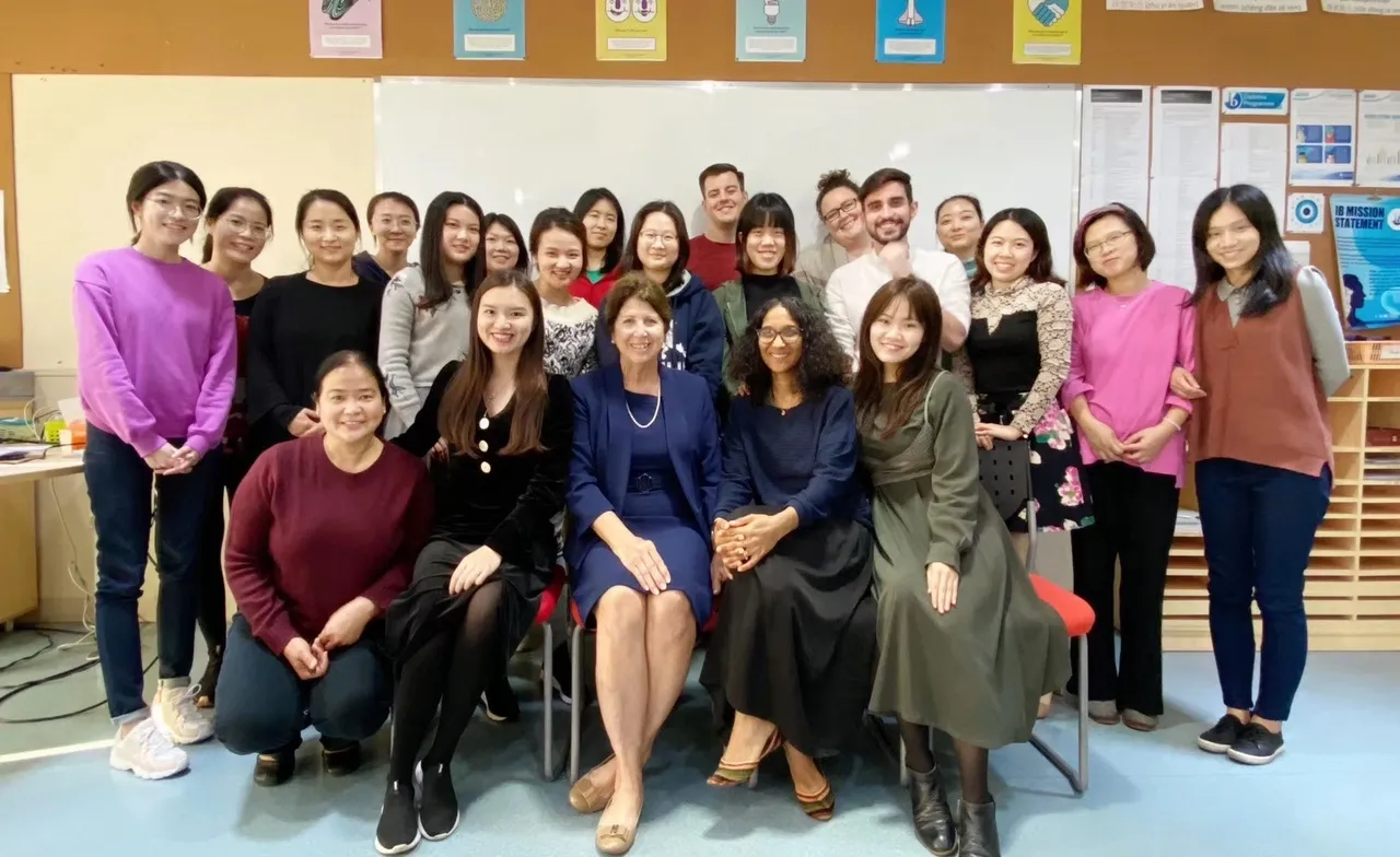 A diverse group of people posing indoors for a group photo.